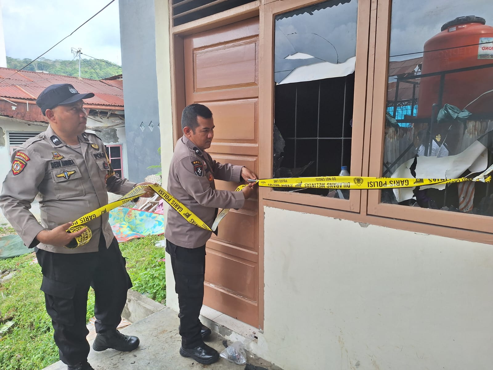 Petugas kepolisian memasang garis polisi di Kelurahan Berok Nipah, Kecamatan Padang Barat, Kota Padang, Senin sore (22/9/2025), setelah seorang penghuni mencoba bunuh diri dengan membakar diri.