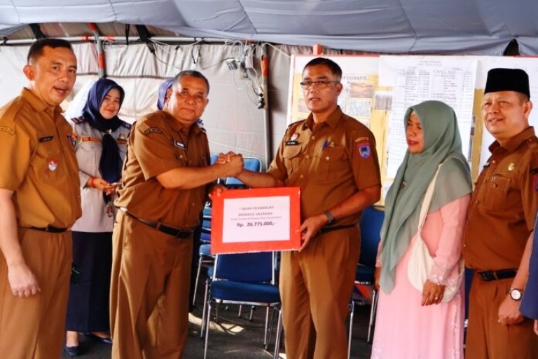 PEDULI: Kepala Dinas Pendidikan Payakumbuh, Dasril menyerahkan donasi sebesar Rp26.775.000 kepada Sekretaris Kota Payakumbuh, Rida Ananda di posko kebakaran Pasar Payakumbuh, Selasa (23/09).