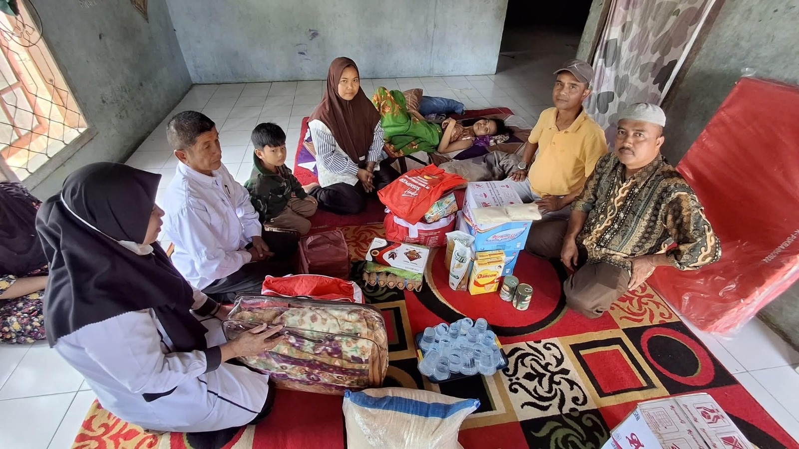 RINGANKAN BEBAN: Kepala Dinas Sosial P3APPKB Martin Efendi menyerahkan bantuan logistik kepada Elsi Fitria di Lubukbulang, Nagari Gunungselasih, Kecamatan Pulaupunjung, Rabu (24/9).