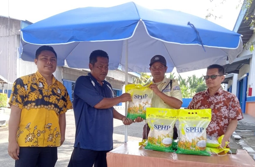 MURAH: Petugas Gudang Bulog Sago Adel didampingi Kepala Gudang Bulog Sago Jum Hendri (paling kanan) melayani warga ketika membeli beras pada stan yang disediakan di Gudang Bulog Sago, Kamis (25/9).
