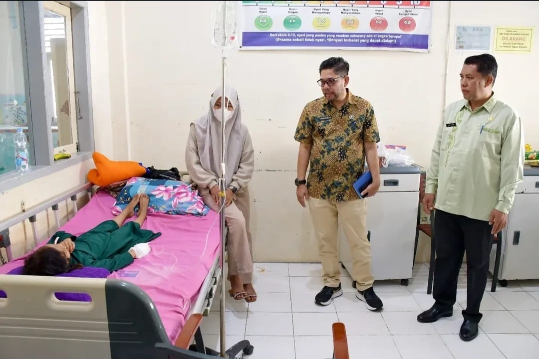 Sekdakab Agam Dr Mhd Lutfi (kanan) mengecek kondisi siswa yang tengah menjalani perawatan, pasca keracunan Makanan Bergizi Gratis (MBG), di RSUD Lubukbasung, Kamis (2/10/2025).