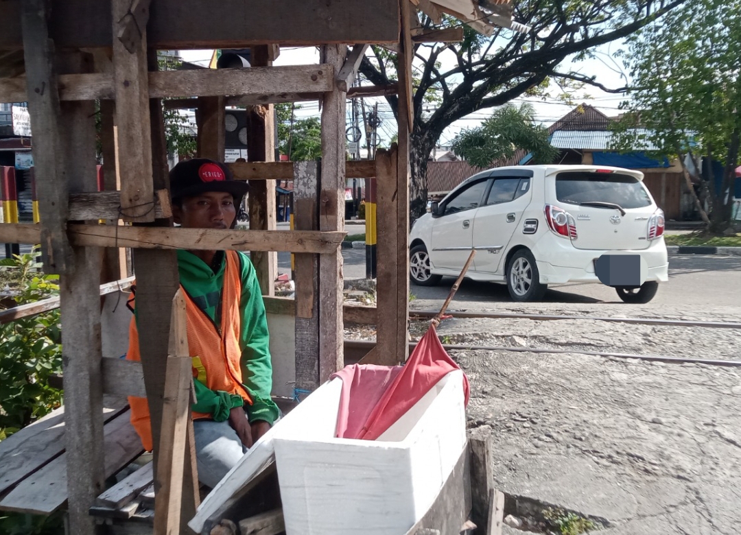 Riki, relawan penjaga pintu rel Kayu Kalek di Padang yang setiap hari mengatur lalu lintas demi keselamatan pengendara.(Foto: Imam/Padek)