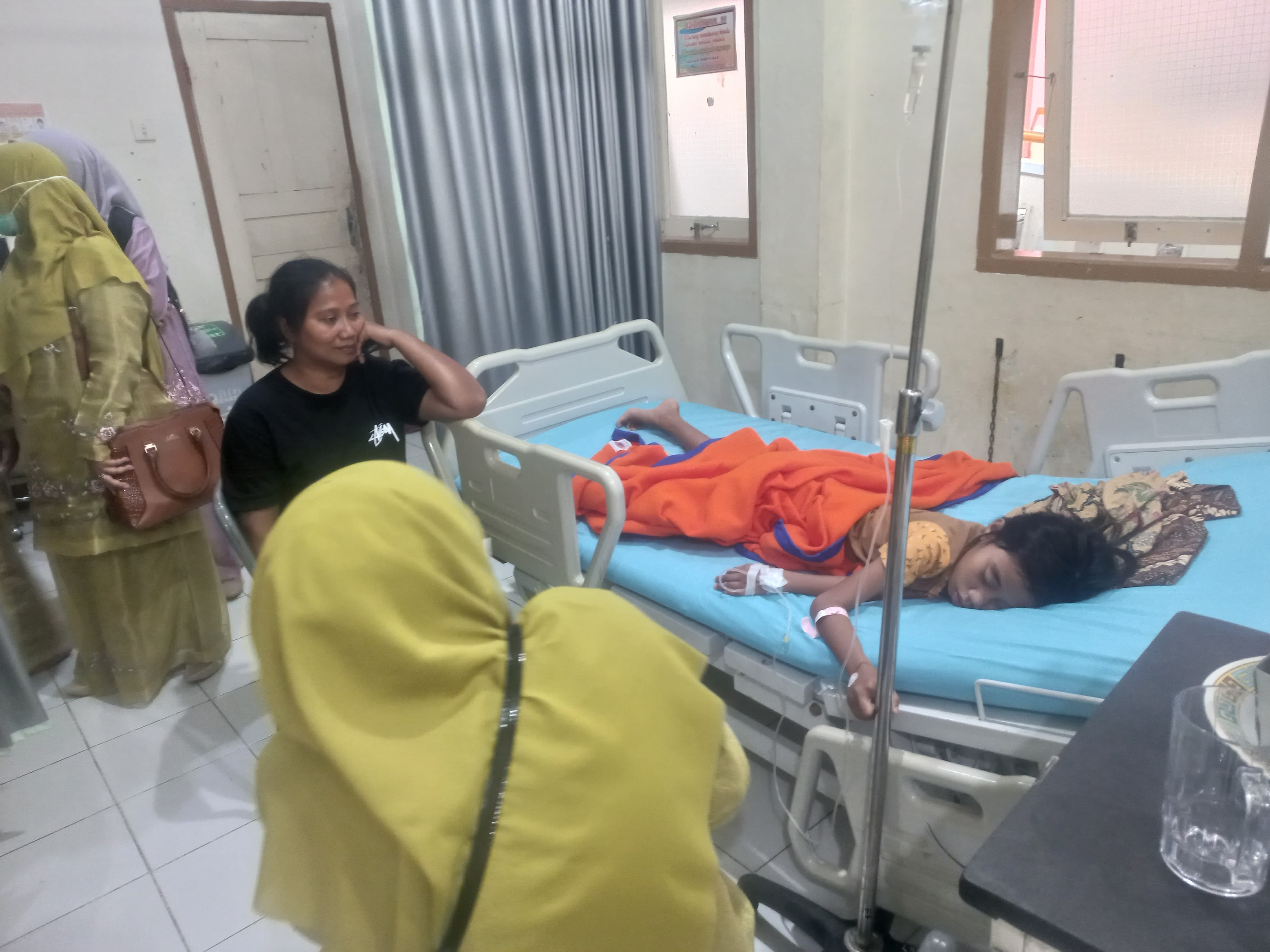 BERHARAP CEPAT PULIH: Darsusi, warga Batuhampar, terus berjaga di samping putrinya, Syafira Maydrianti, salah satu korban dugaan keracunan Makanan Bergizi Gratis (MBG)di Lubukbasung, Agam.