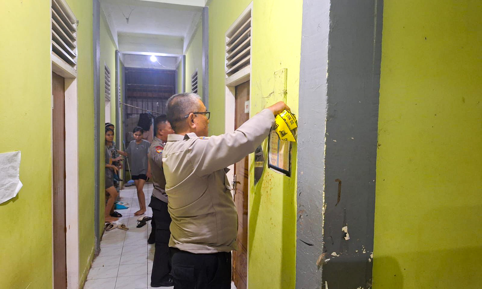 Petugas kepolisian memasang police line di rumah kos tempat meninggalnya N (24), Sabtu malam (11/11/2025). (Foto: Polsek Padang Barat)