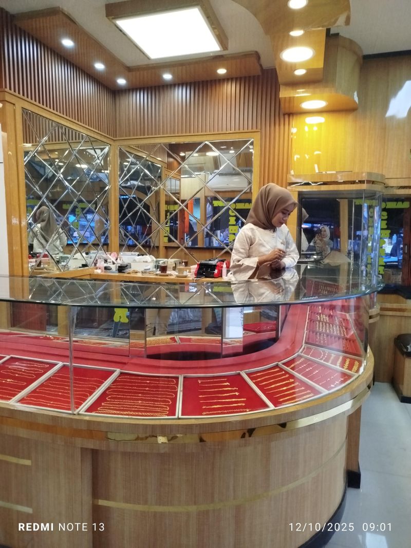 Era, pemilik Toko Emas Cempaka di pasar tradisional Pulau Punjung, Kabupaten Dharmasraya sedang menunggu pembeli.