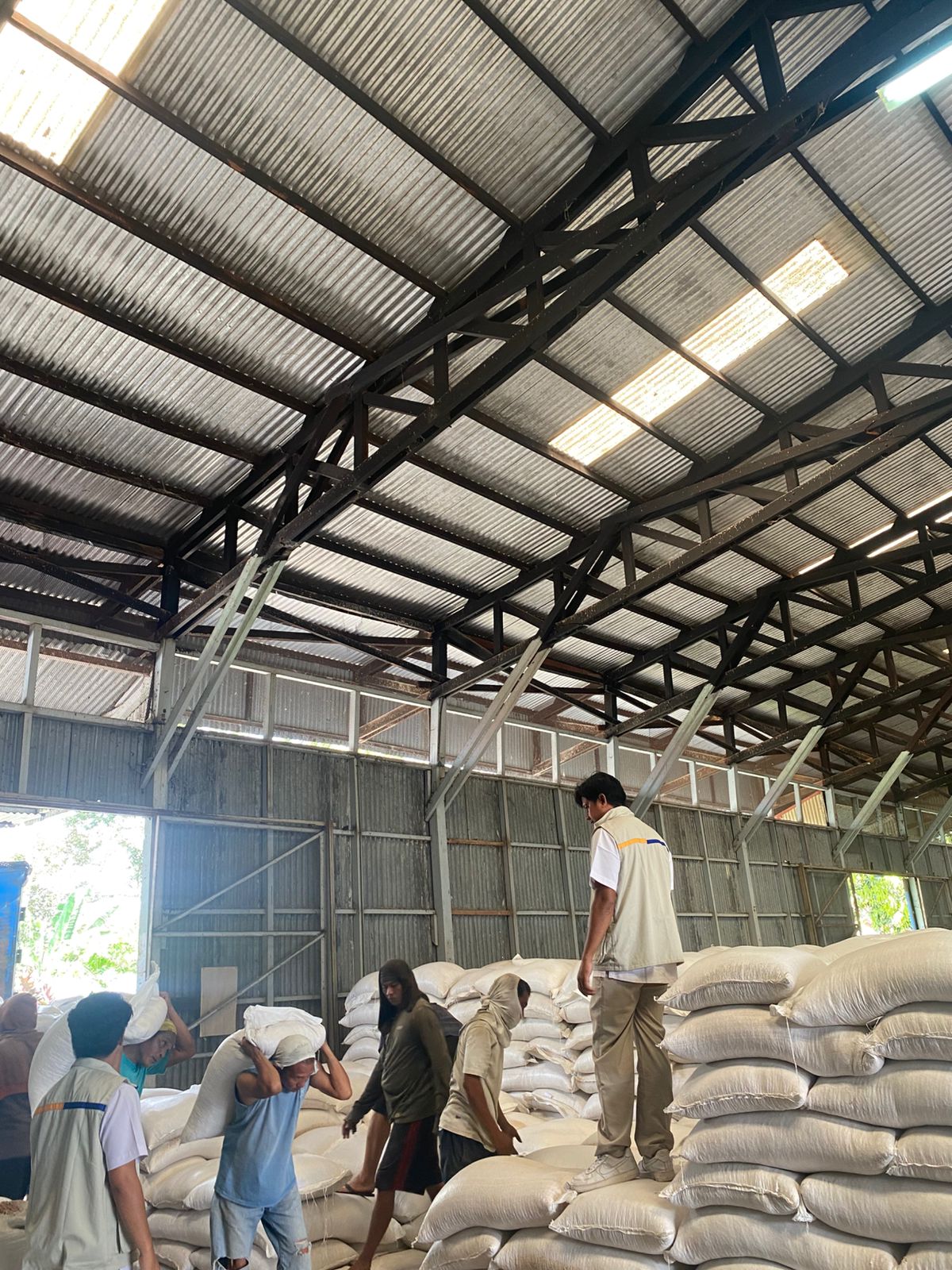 Sejumlah pekerja mengangkat jagung ke dalam gudang Bulog Sumbar.