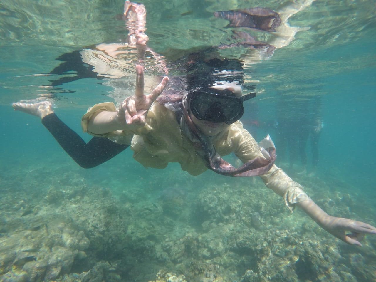 Salah seorang wisatawan menikmati keindahan bawah laut di kawasan Pulau Setan.