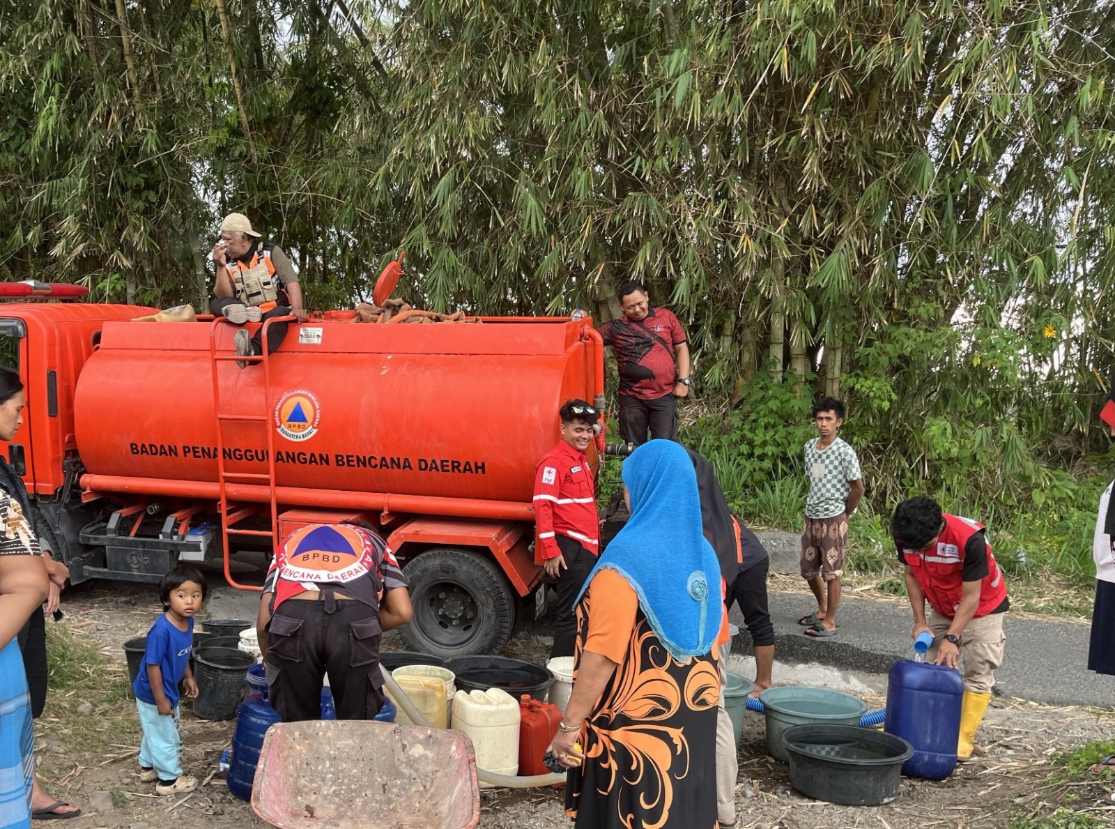 SUPLAI AIR BERSIH: Petugas BPBD Agam menyalurkan air bersih kepada warga terdampak kekeringan di Kecamatan Ampekangkek dan Canduang, baru-baru ini.