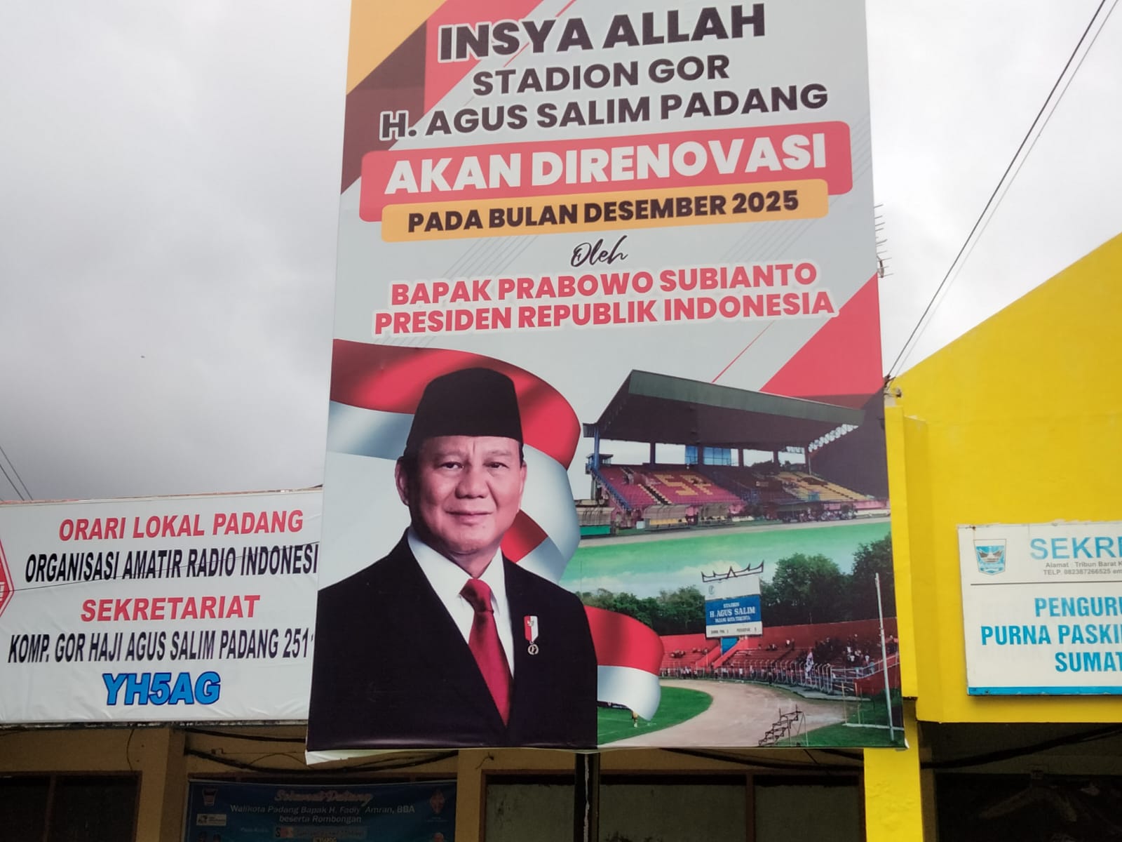 Sebuah baliho tentang rencana renovasi Stadion GOR Haji Agus Salim Padang pada Desember 2025 terpajang di kawasan stadion.