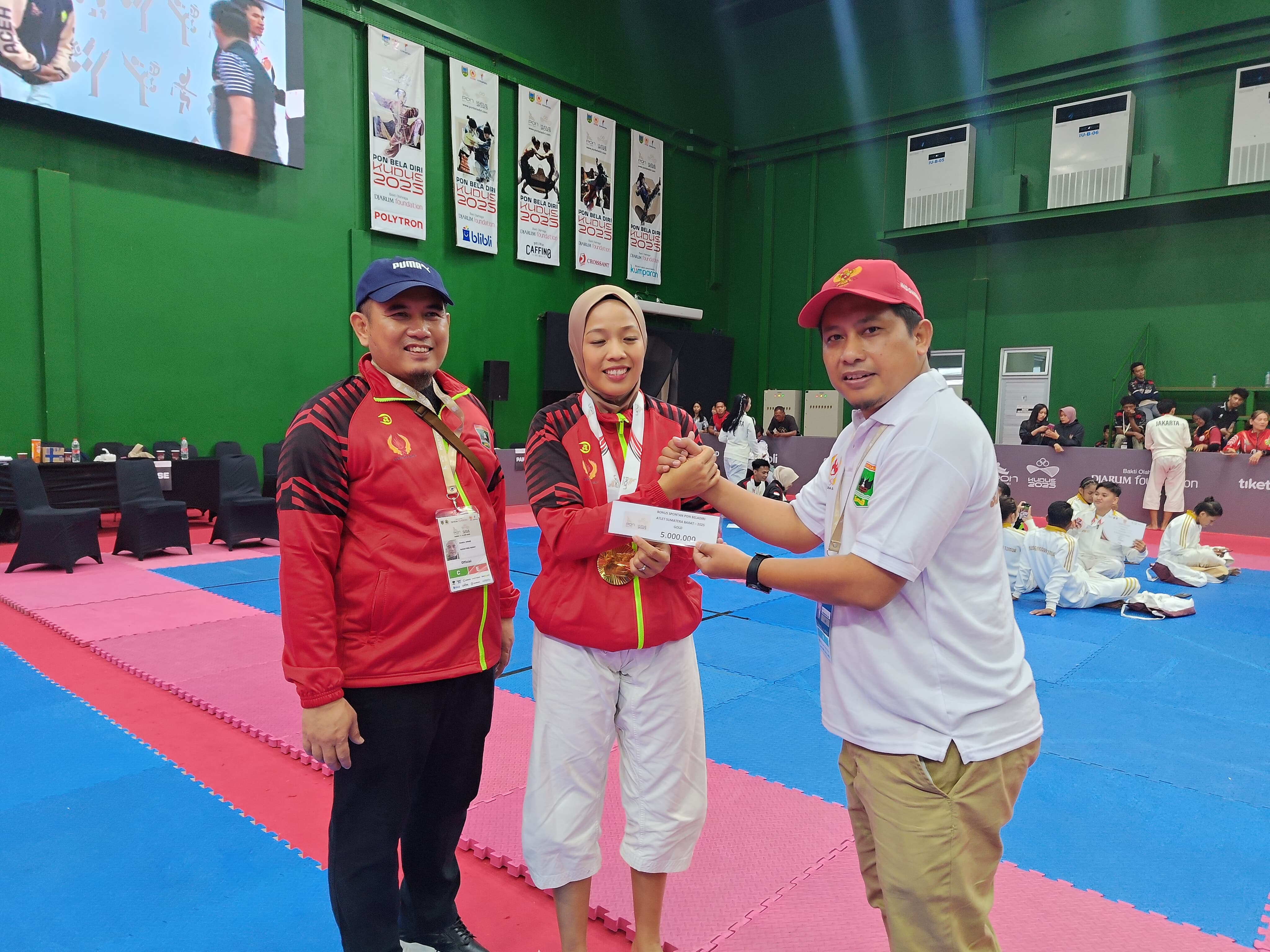 Ketua Umum KONI Sumbar Hamdanus disaksikan Wakil Ketua Umum Nurul Ikhsan menyerahkan bonus spontan kepada peraih medali emas Kempo Putri Suci Kurnia Dewi. (Foto Humas KONI Sumbar)