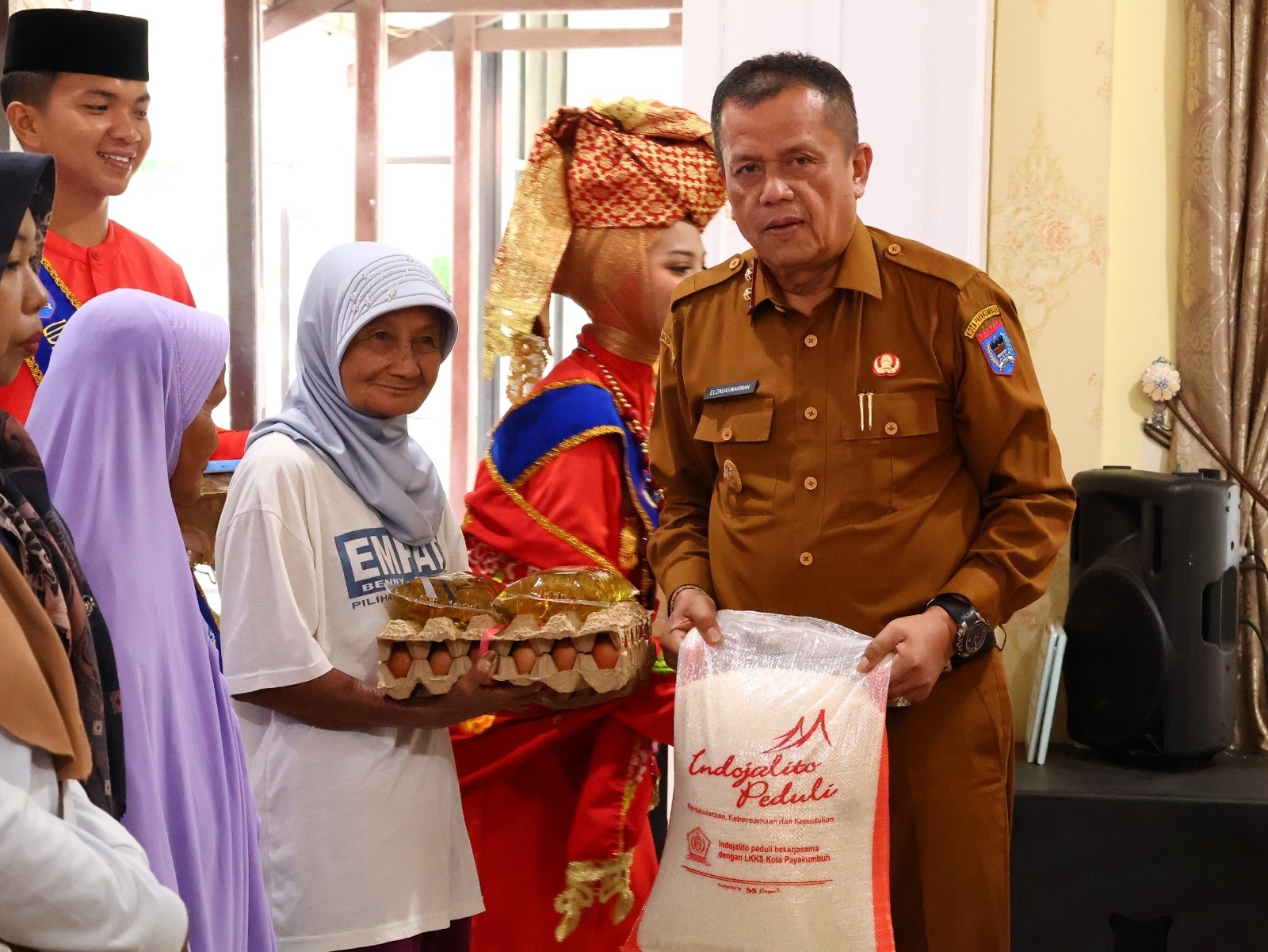 PENYERAHAN BANTUAN SOSIAL: Wakil Wali Kota Payakumbuh Elzadaswarman menyerahkan secara simbolis paket sembako kepada warga, didampingi Ketua Umum LKKS Kota Payakumbuh Eni Zulmaeta.