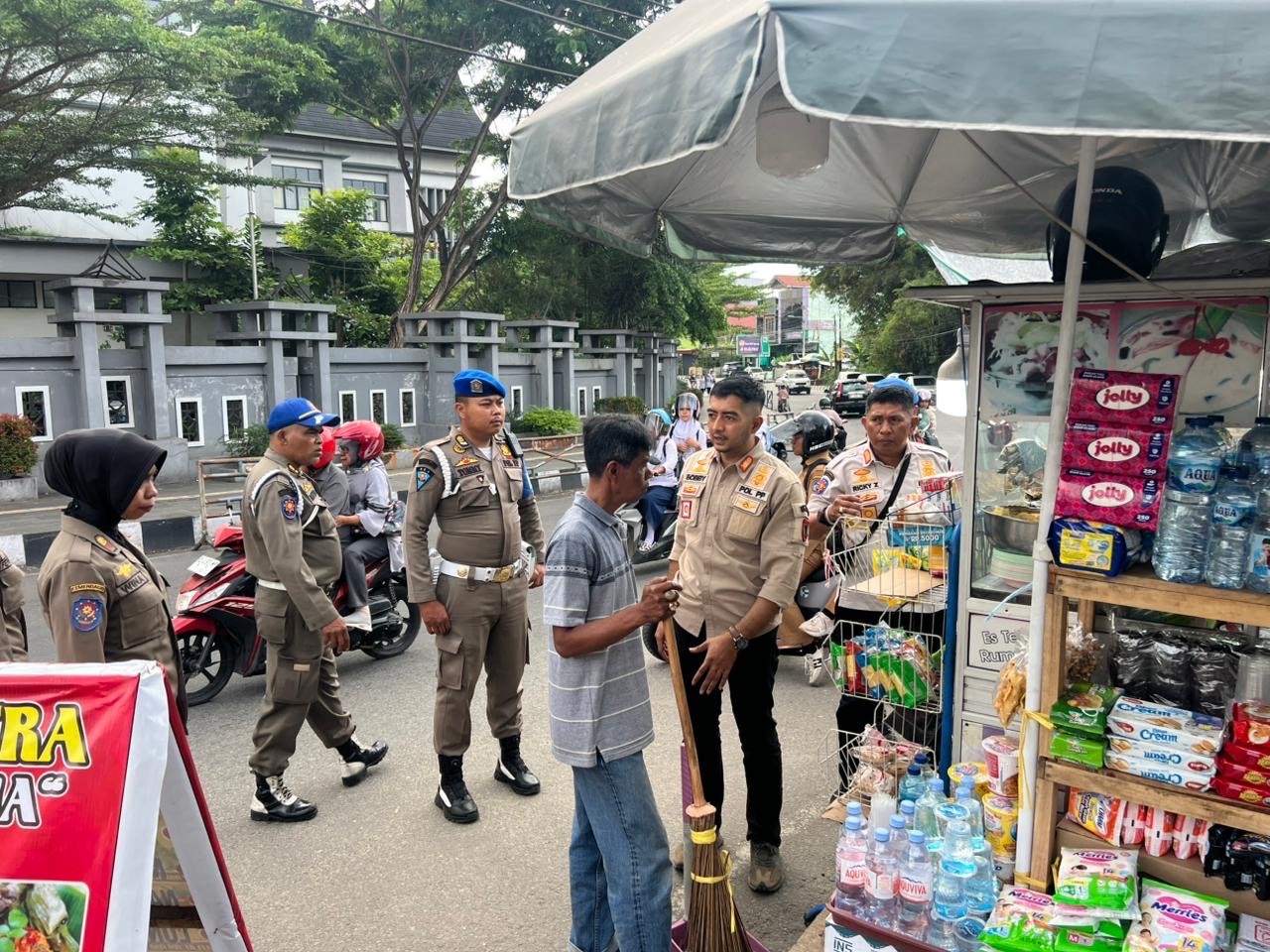 AMBIL TINDAKAN: Petugas Satpol PP Kota Payakumbuh memberikan teguran kepada pedagang kaki lima yang berjualan di bahu jalan depan RS Ibnu Sina, Payakumbuh.