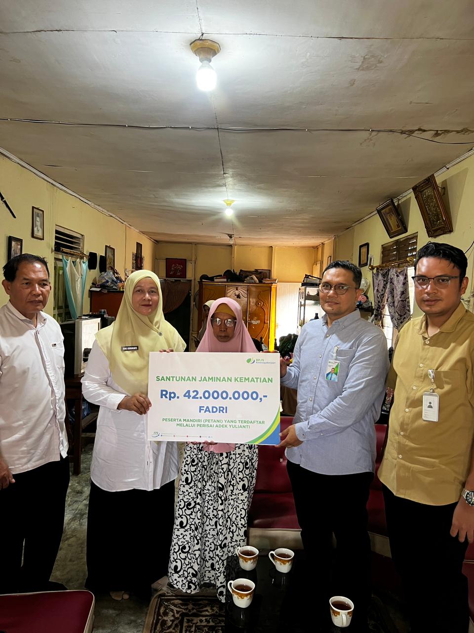 Kepala BPJS Ketenagakerjaan (BPJAMSOSTEK) Cabang Solok, Maulana Anshari Siregar, menyerahkan secara simbolis manfaat Program Jaminan Kematian (JKM) kepada ahli waris.