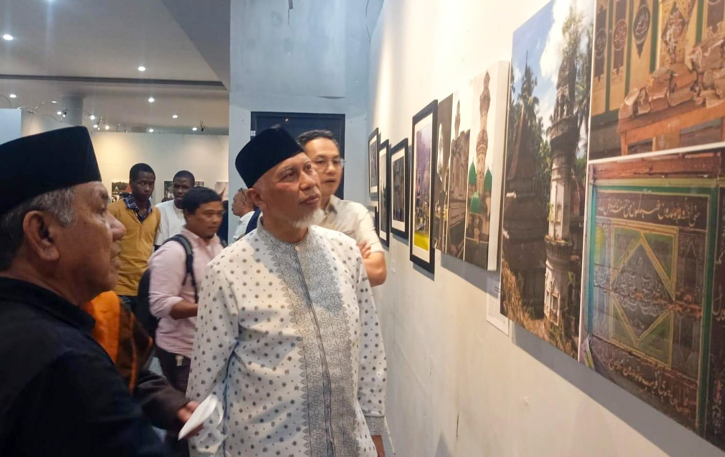Edy Utama menjelaskan karya potretnya ke Gubernur Mahyeldi pada malam pembukaan peresmian pameran, Jumat (24/10/2025) malam. (Foto: Riyadhatul Khalbi/Padeks)