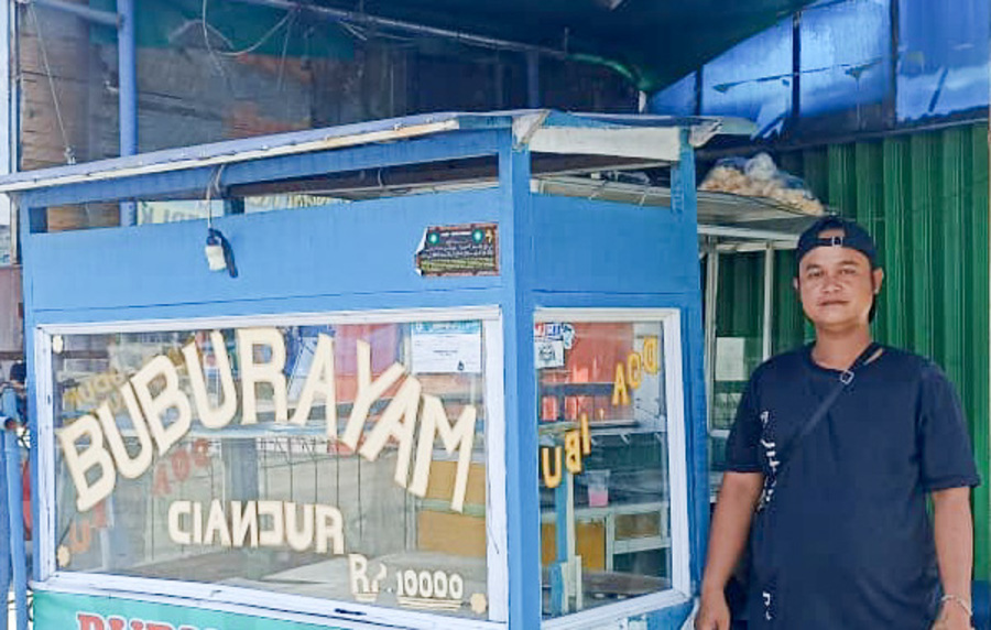 Anggi dan lapak jualan bubur ayamnya di Jalan Adinegoro, Lubuk Buaya. (Foto: Fadli Zikri/Padeks)
