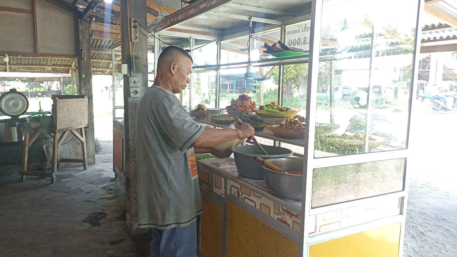 Salah seorang pedagang nasi di kawasan Kototangah sedang mengambilkan pesanan pembeli, kemarin.