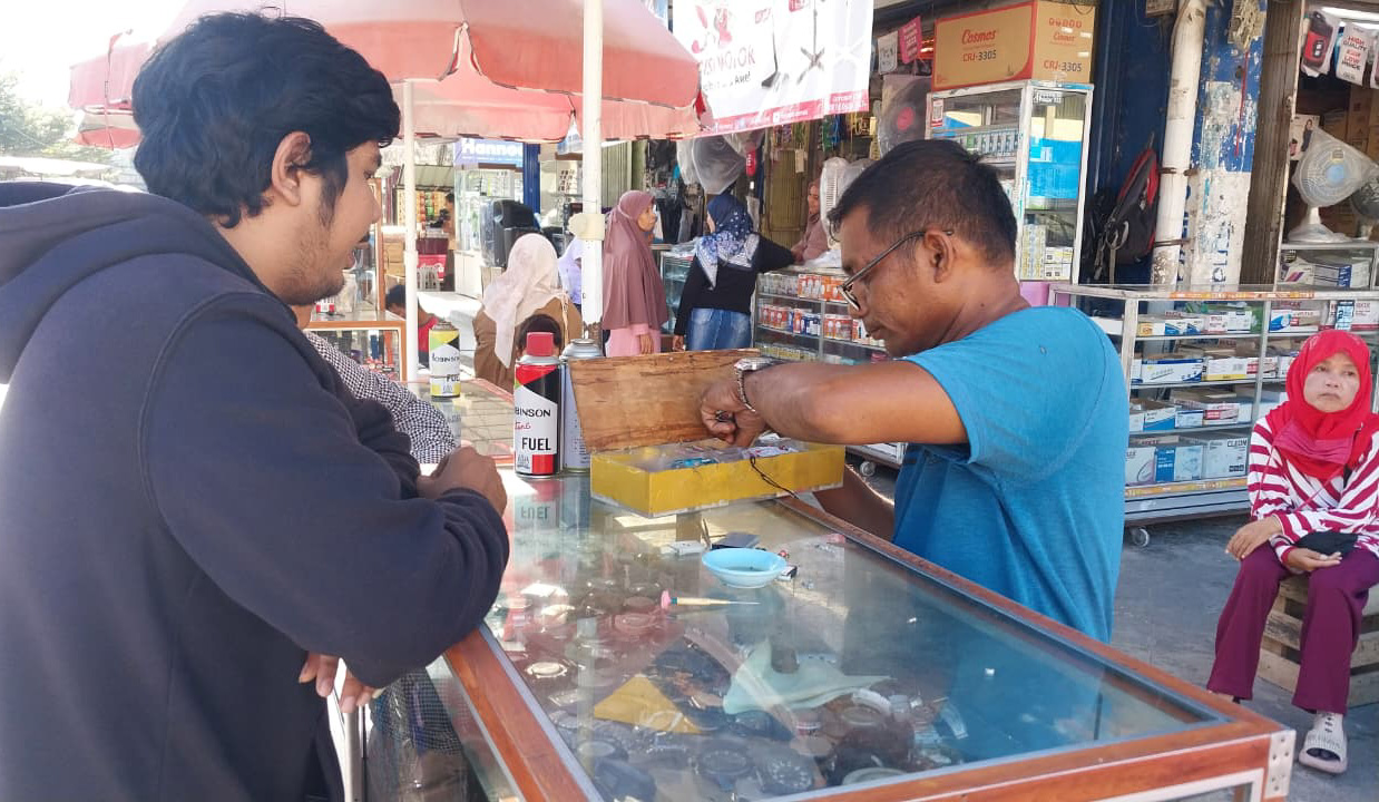 Syahrial saat melayani pelanggan servis jam tangan di Pasar Raya Padang. Semua kebutuhan keluarga dipenuhi dari putaran jarum jam yang ia rawat setiap hari. (Foto: Mengki Kurniawan/Padeks)