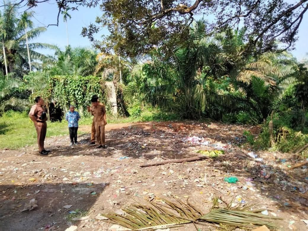 PERLU LAKUKAN PEMBERSIHAN: Petugas Dinas Lingkungan Hidup Dharmasraya meninjau area belakang SMPN 3 Sitiung yang sebelumnya dilaporkan masyarakat karena tumpukan sampah.