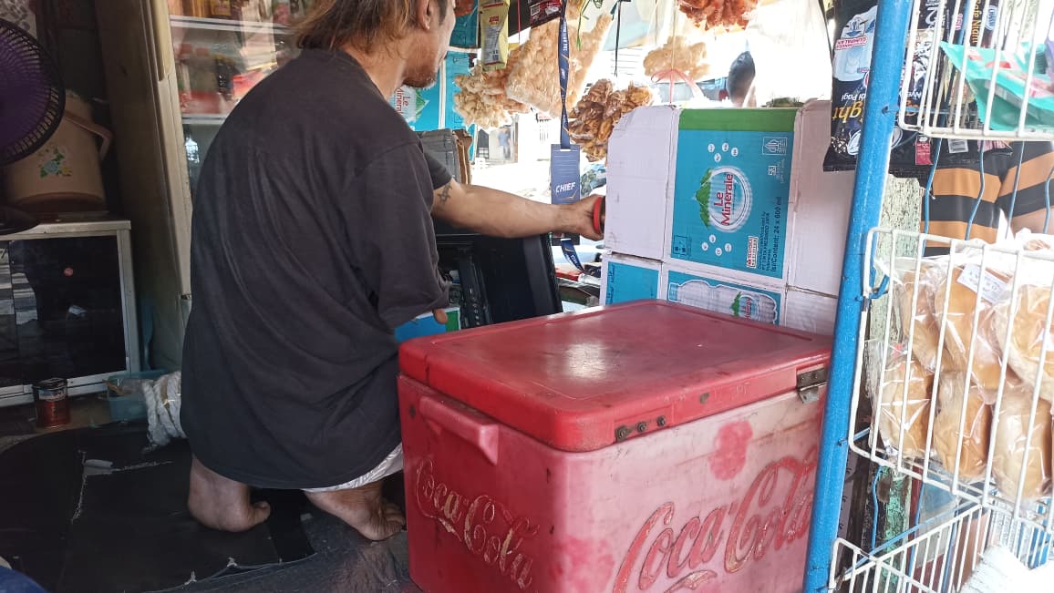 Nasrul, pedagang disabilitas di Padang, tetap berjuang setiap hari dengan satu tangan demi keluarganya, membuktikan semangat tak kenal batas. (Foto: Fadli Zikri/Padeks)