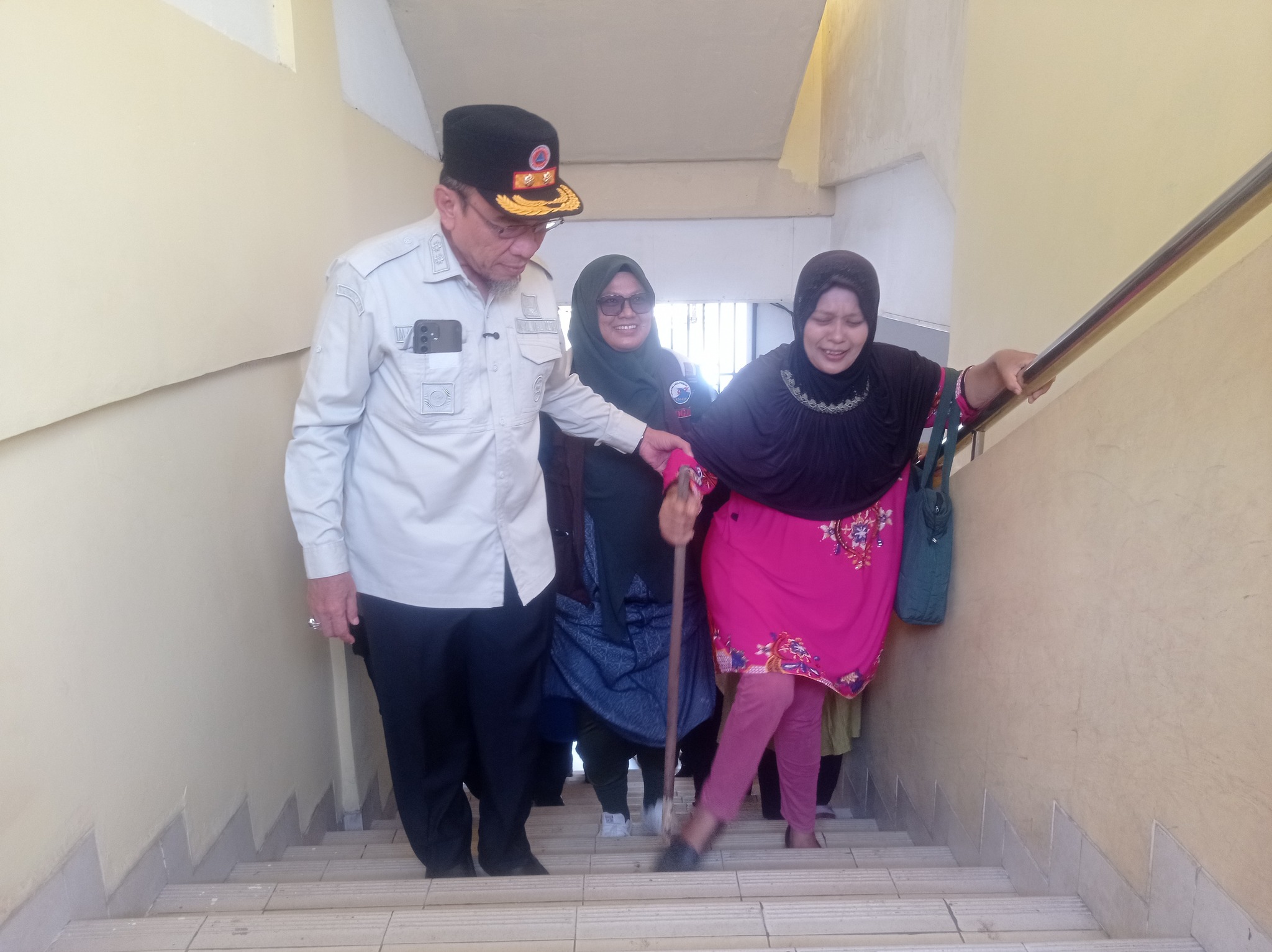 Wawako Padang Maigus Nasir menuntun warga lanjut usia naik shelter saat simulasi gempa di SMPN 25 Padang.