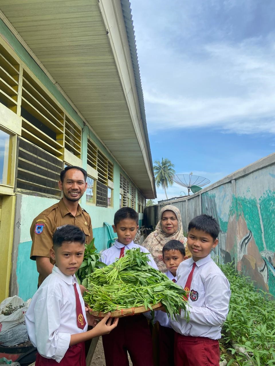BANGGA: Murid SD Negeri 21 Payakumbuh menunjukan hasil penen mereka.