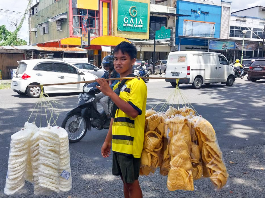 Kisah inspiratif Egi Musmail, remaja penjual kerupuk di Padang yang rela putus sekolah demi membantu keluarga dan perjuangkan mimpi saudaranya. (Foto: Mengki Kurniawan/ Padeks)