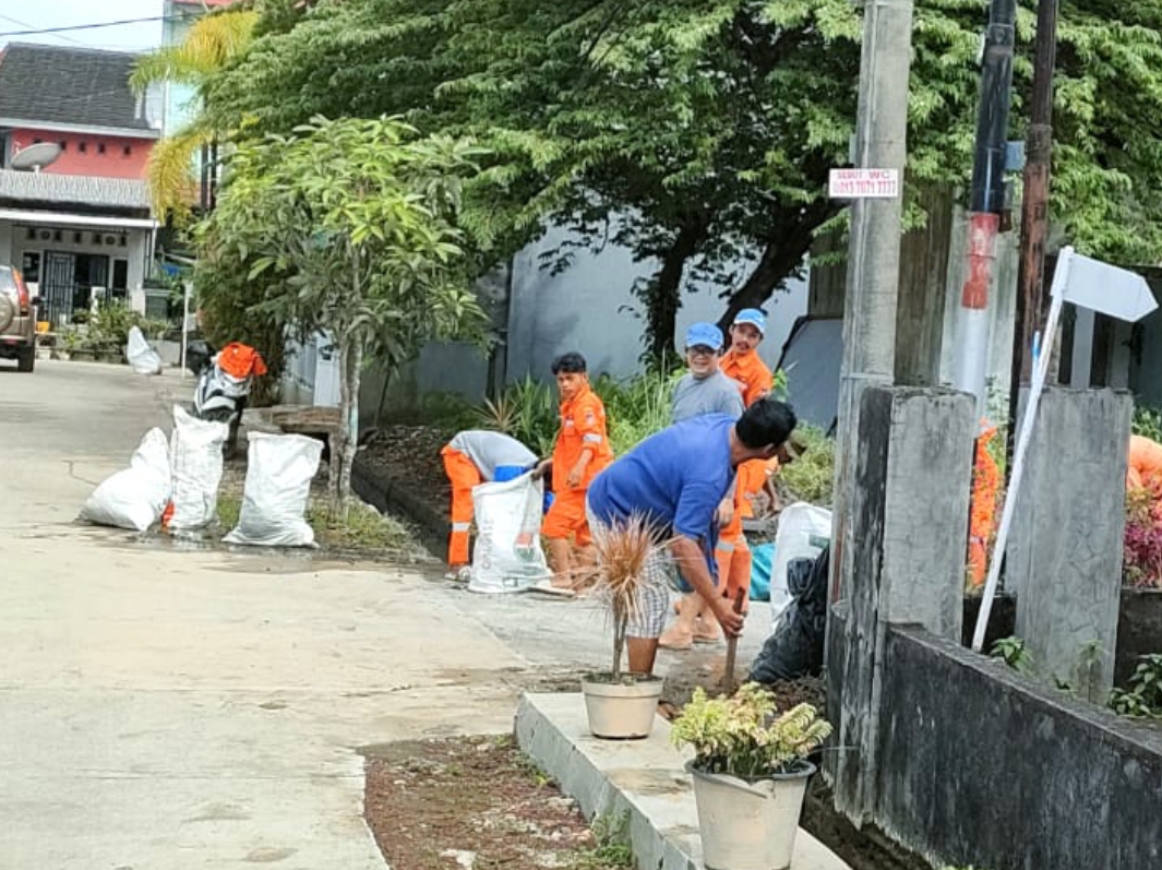 Warga dibantu petugas DLH Padang goro mengangkat sampah kiriman dari saluran irigasi yang masuk ke drainase kompleks PSG, beberapa waktu lalu. (Foto: Dok RT)