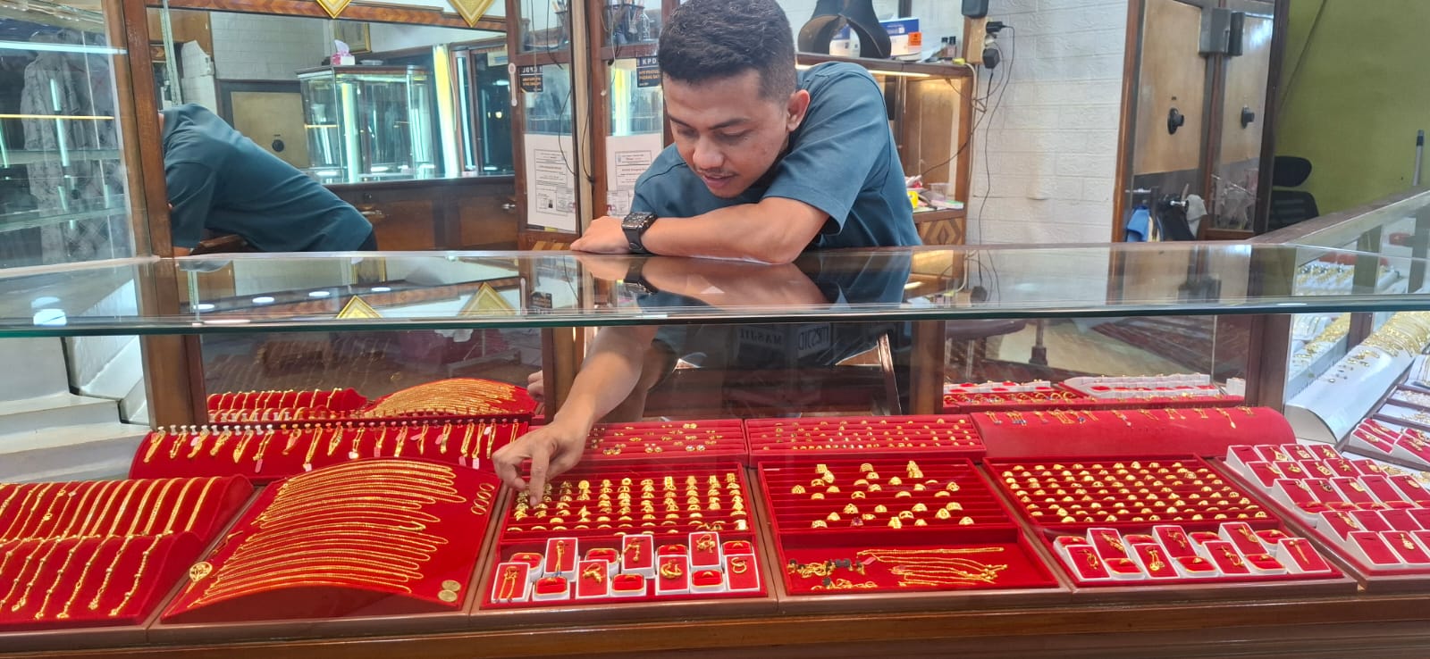 Pedagang toko emas di Pasar Raya Padang sedang menyusun emas perhiasan, Kamis (6/11).