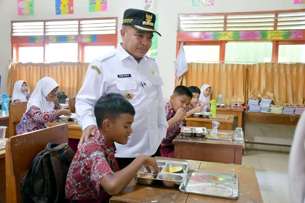 Bupati Agam Benni Warlis (berdiri) meninjau pelaksanaan Makan Bergizi Gratis (MBG) di SDN 08 Bukikbatabuah, Canduang, beberapa waktu lalu.