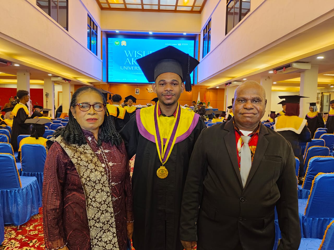 Yancway SPd dan Welmina Imbiri, yang menempuh ribuan kilometer dari Sorong Selatan, Papua Barat Daya, demi satu momen berharga: menyaksikan Stevanus Aser Way diwisuda di UBH Padang.
