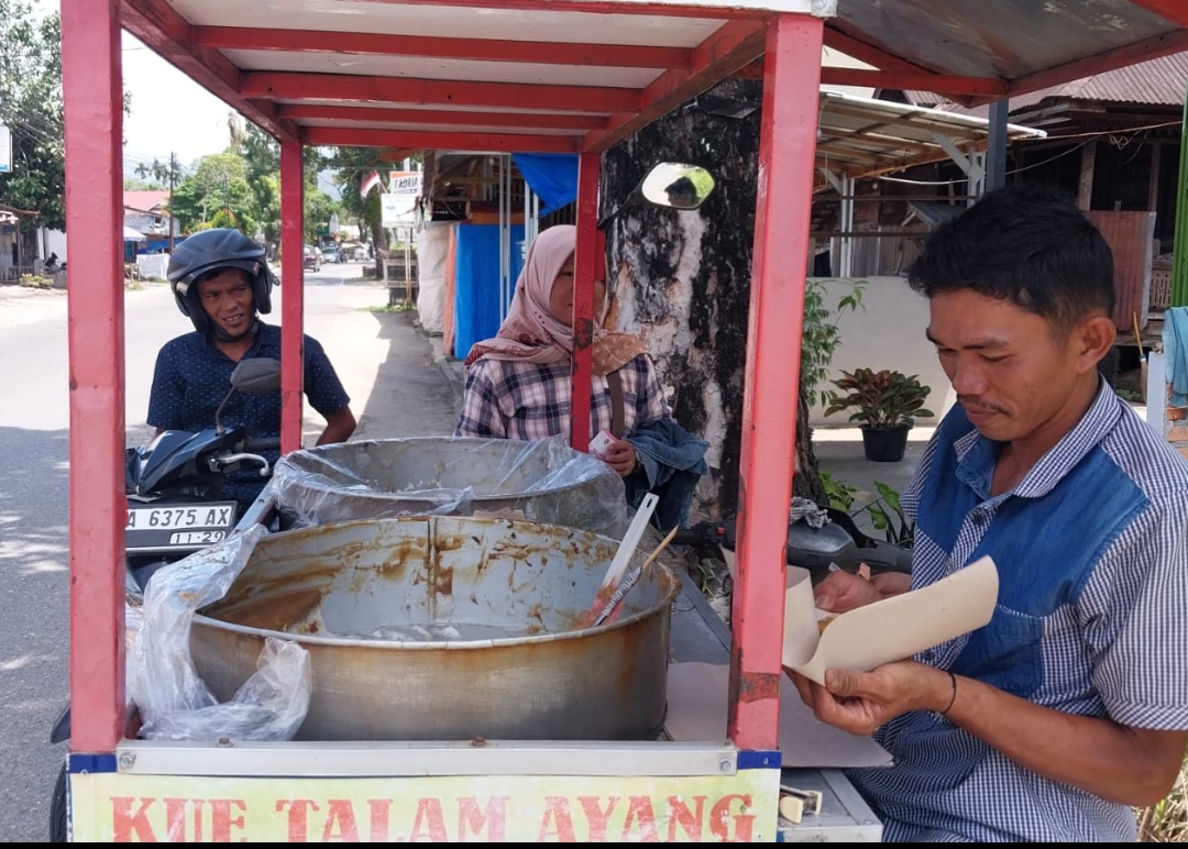 Ikil Saputra menjajakan Kue Talam dagangannya di kawasan Jl. Raya Air Dingin, Kelurahan Balai Gadang, Kecamatan Koto Tangah, Kota Padang. (Foto: Mengki Kurniawan/Padek)
