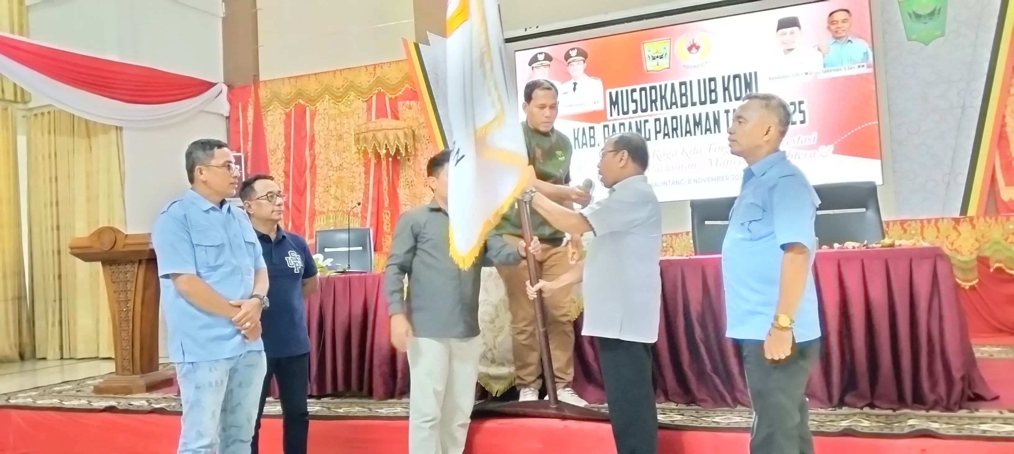 Asmadi saat menerima pataka KONI, setelah terpilih secara aklamasi sebagai Ketua KONI Padangpariaman, Sabtu (8/11).