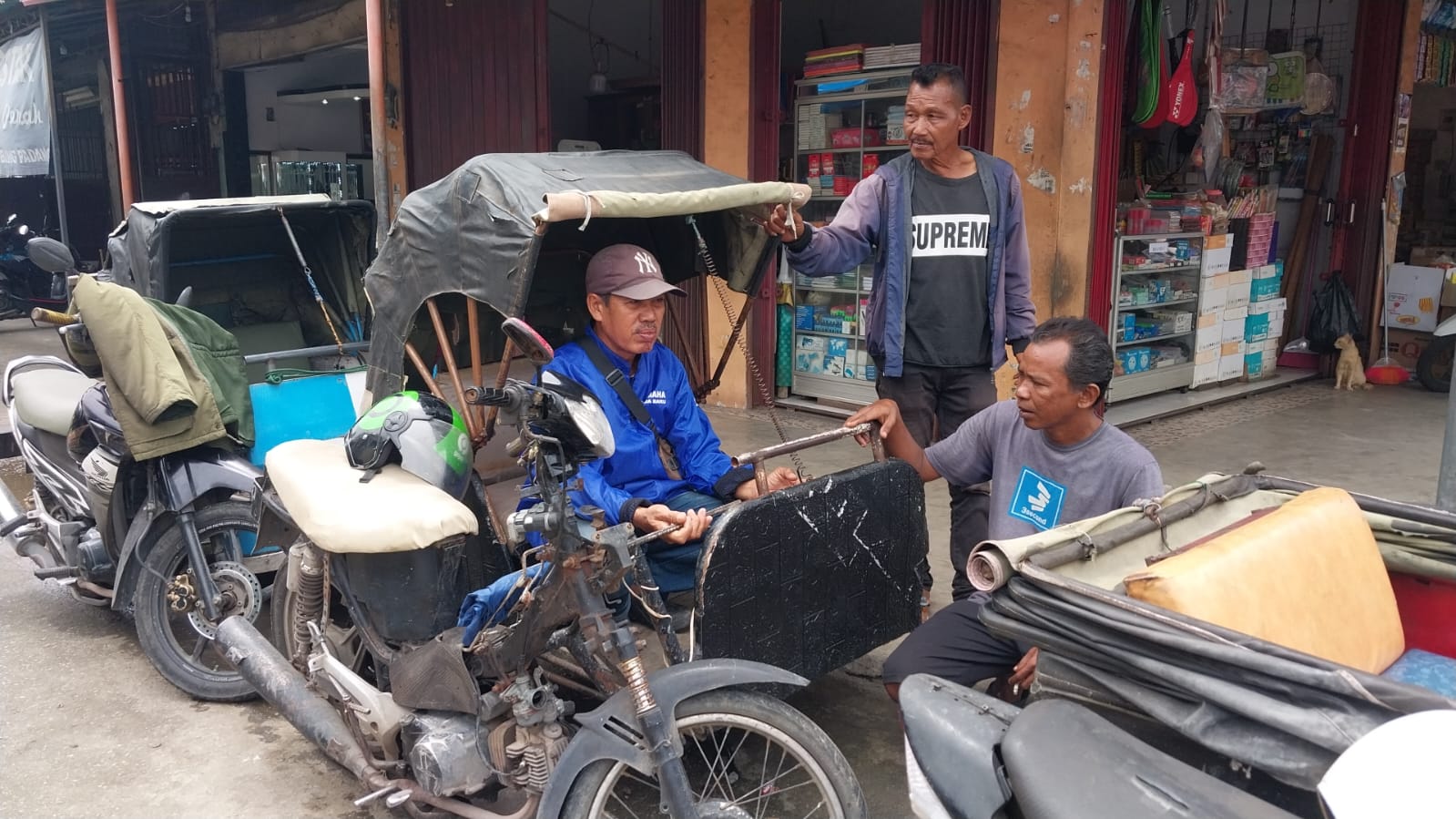 Azwendi (jaket biru), tukang becak motor di Pasar Belimbing, Padang, yang dengan penghasilan pas-pasan berhasil menyekolahkan empat anaknya hingga sarjana.