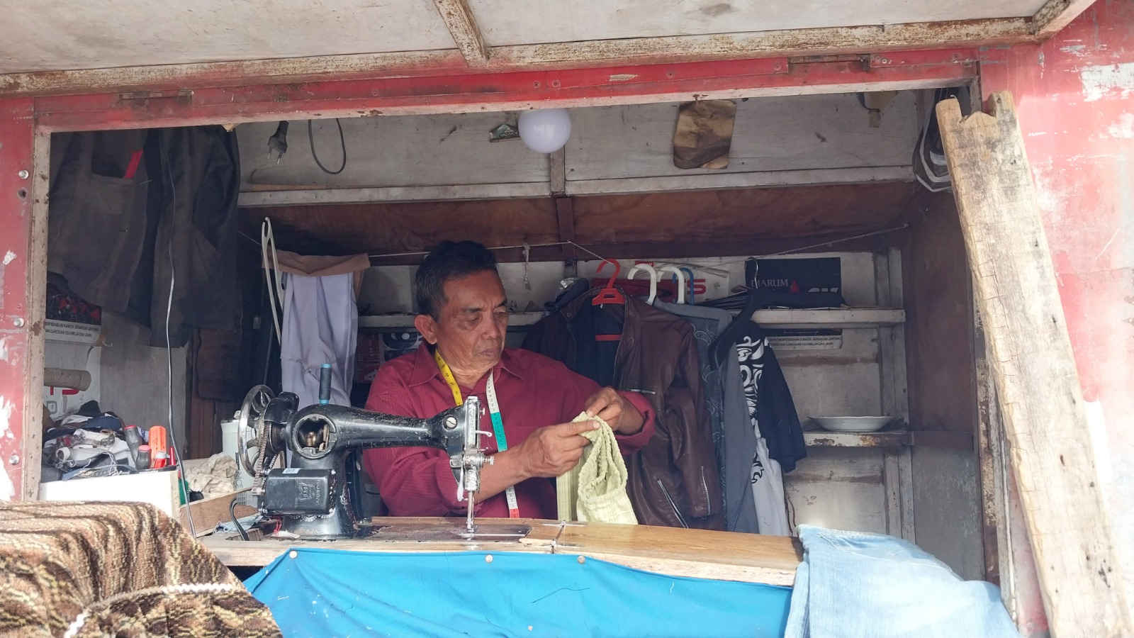Man Balingka, penjahit di kawasan Jalan Permindo, sedang menjahit baju pelanggannya, Rabu (12/11).