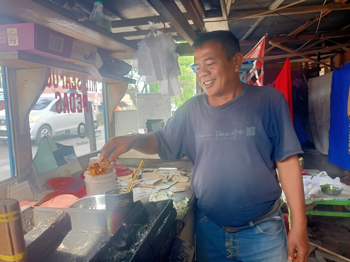 Oyon, pedagang sate di Jalan Moh Hatta Padang yang selama 30 tahun bertahan dan berhasil menyekolahkan dua anaknya hingga kuliah. (Foto: M Reza BP/Padeks)