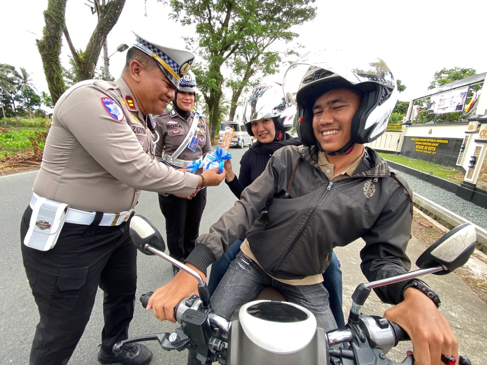 APRESIASI: Kasat Lantas Polres Limapuluh Kota, Iptu Zarwiko Irzal, memberikan bunga dan cokelat kepada pengendara yang tertib berlalu lintas, kemarin.