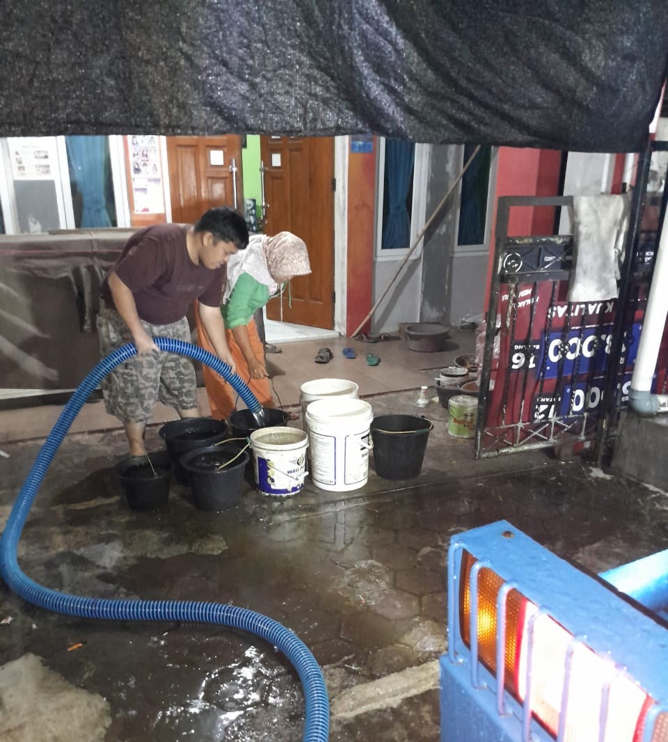 Pelanggan PDAM di kawasan Limaumanis menampung air dari mobil tangki Perumda Air Minum Kota Padang Sabtu (22/11).