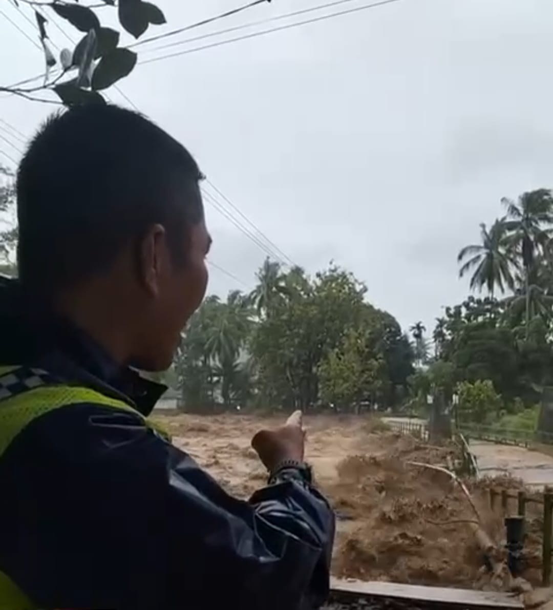 Seorang warga menunjuk pipa PDAM yang putus diterjang arus sungai yang deras di kawasan Limaumanis Kamis (27/11) pagi.