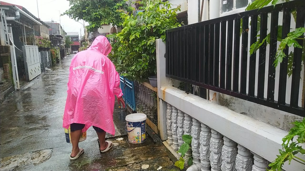 Henpri (47), warga Siteba, menampung air hujan sejak pagi untuk kebutuhan keluarga, Kamis sore (27/11/2025).