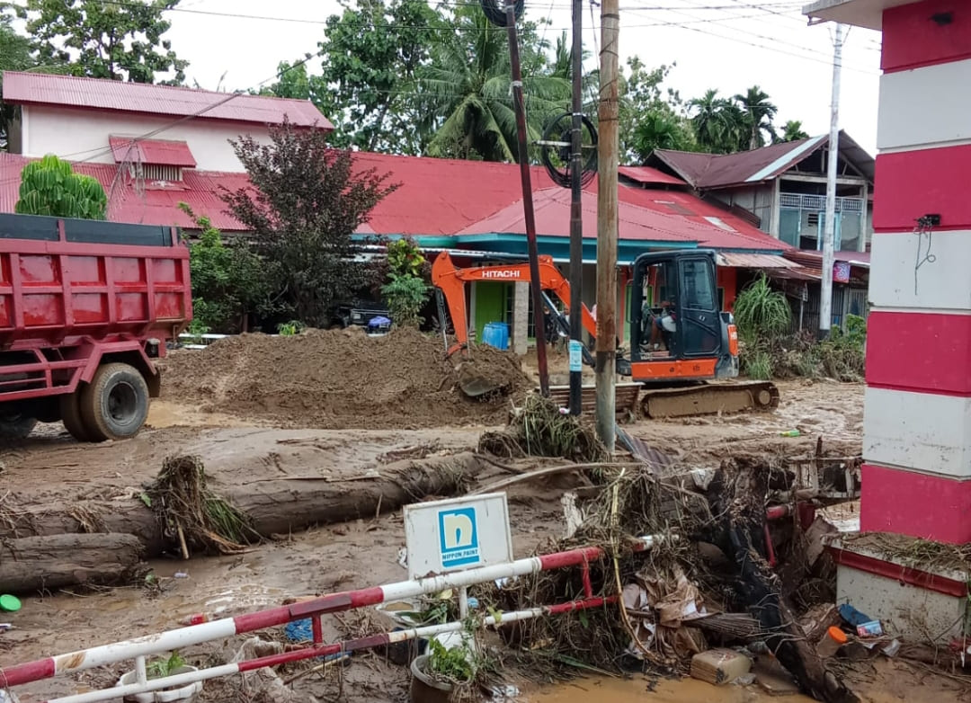 Alat berat membersihkan tumpukan material banjir bandang di Surau Gadang, Padang, Jumat (28/11/2025), setelah puluhan rumah warga terdampak dan akses jalan terputus.(Foto: Zulfahmi)