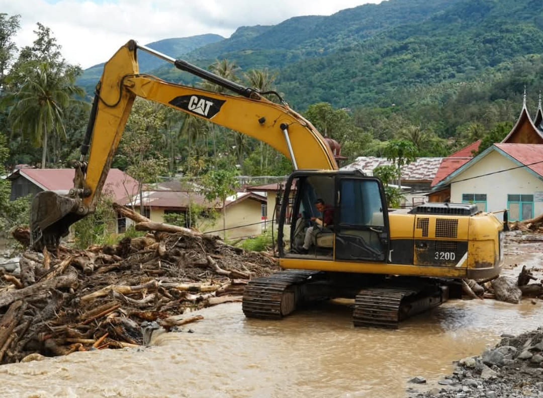 Alat berat milik Pemkab Tanahdatar dikerahkan untuk membersihkan material galodo yang menutup akses jalan di wilayah terdampak, Batusangkar, Minggu (30/11/2025).(Foto: Prokopim)