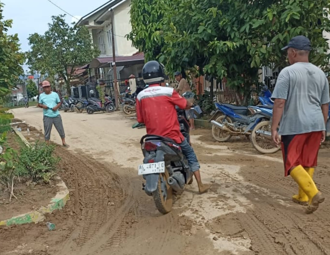 Petugas dari TelkomGroup (bermotor) melintasi lumpur bekas banjir bandang, di Nanggalo, Kota Padang untuk memulihkan jaringan Indihome warga. (Foto: Heri Sugiarto/ Padek)