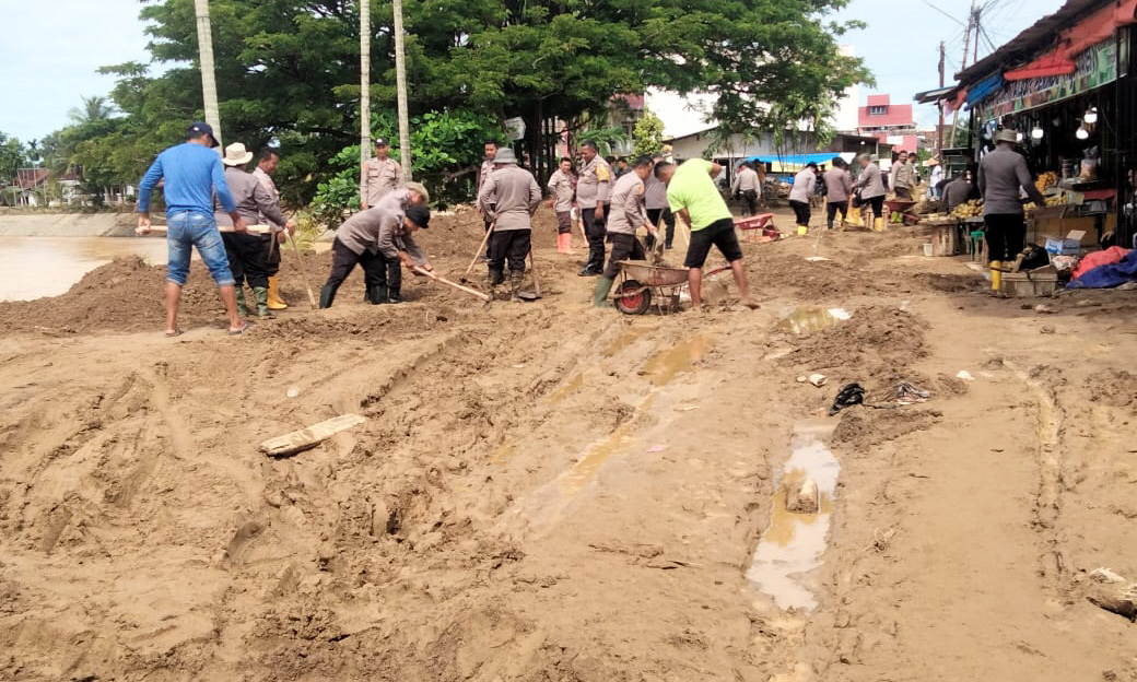 Warga Siteba bersama aparat membersihkan lumpur mengering di Jalan Berok pascabanjir, Minggu (30/11/2025). (Dok: Endang P)