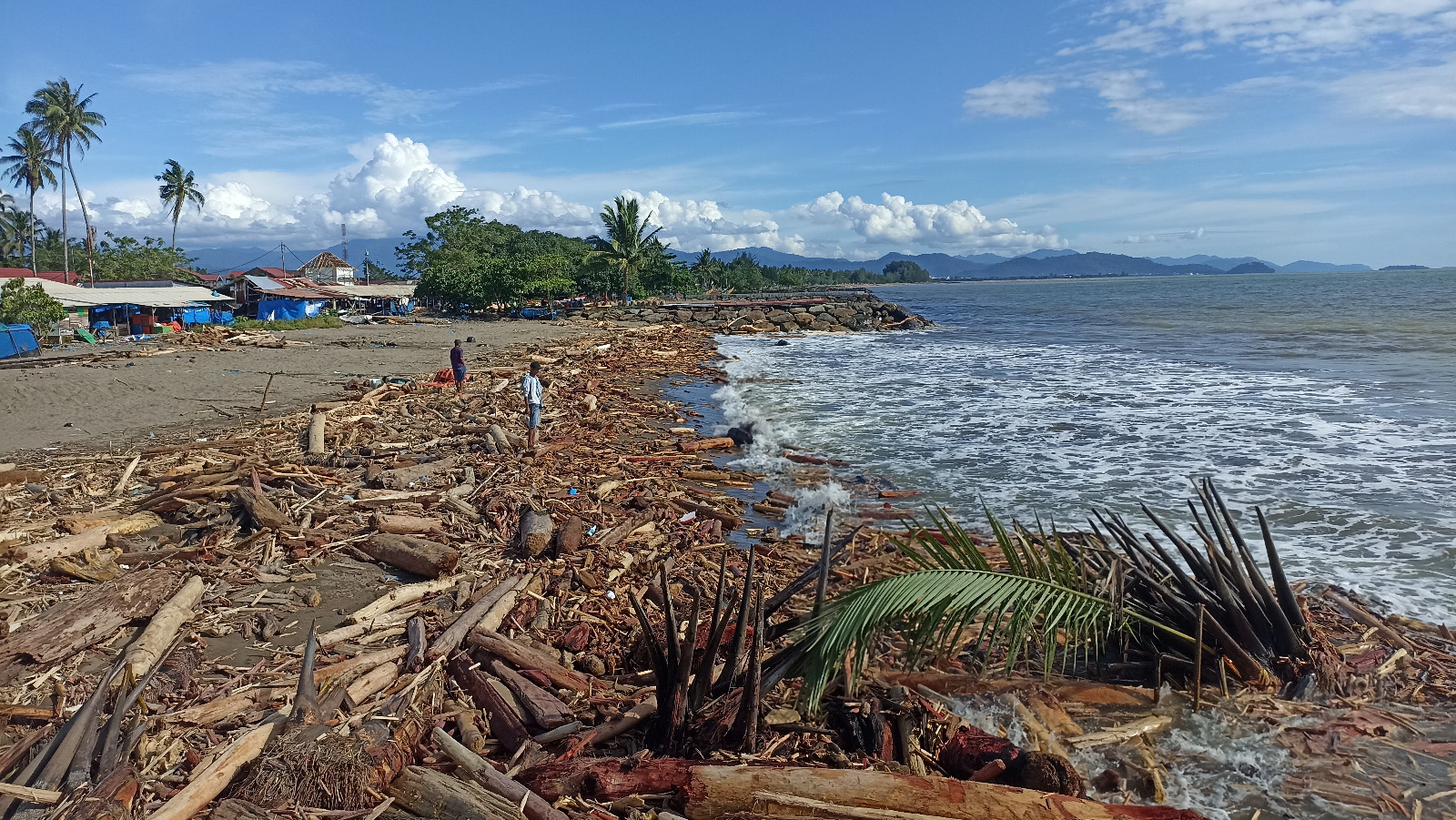 Kondisi bibir Pantai Pasirjambak yang dipenuhi tumpukan kayu pascabanjir, kemarin.
