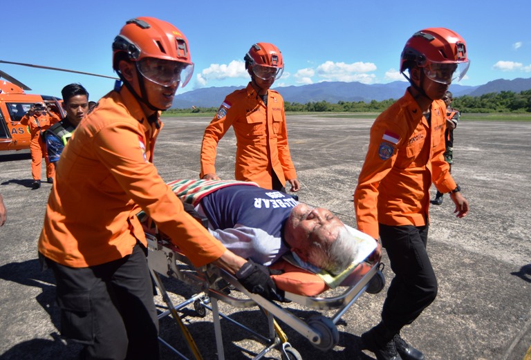Evakuasi: Petugas Basarnas menurunkan korban sakit yang dievakuasi dari helikopter, di Lanud Sutan Sjahrir Padang, Senin (1/12).