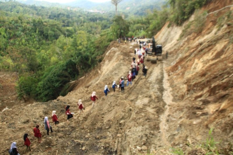 SUDAH BISA DIAKSES: Relawan dan mahasiswa melintasi jalan Sungailandia, Kabupaten Agam yang bertahap sudah bisa diakses setelah tujuh hari terisolasi karena banjir bandang dan tanah longsor.