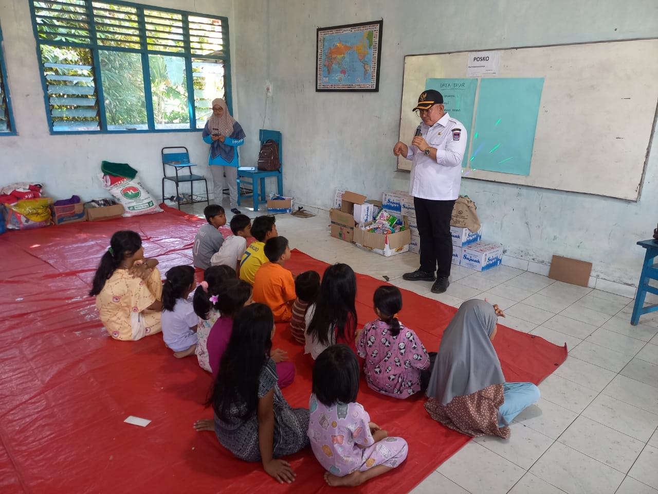 Petugas DP3AP2KB Padang berinteraksi dengan anak-anak di salah satu posko pengungsian di kawasan Lubuk Minturun, kemarin.