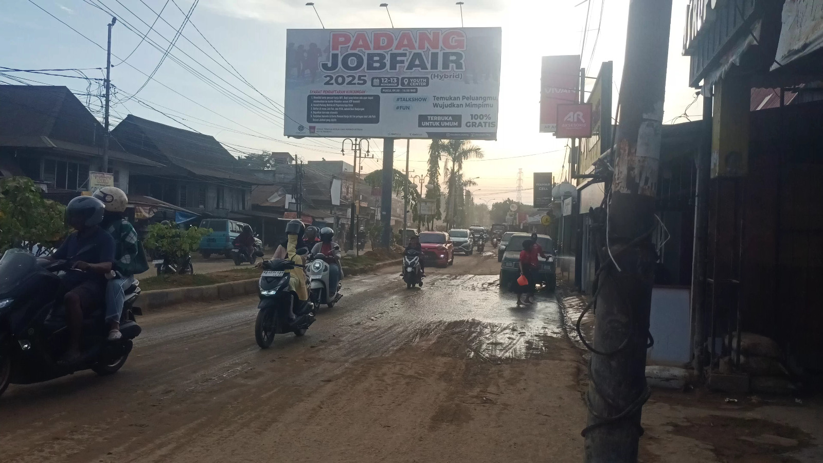 Kondisi di Jalan Moh. Hatta, Kecamatan Pauh, yang masih dipenuhi debu akibat lumpur yang mengering pascabanjir di kawasan itu.