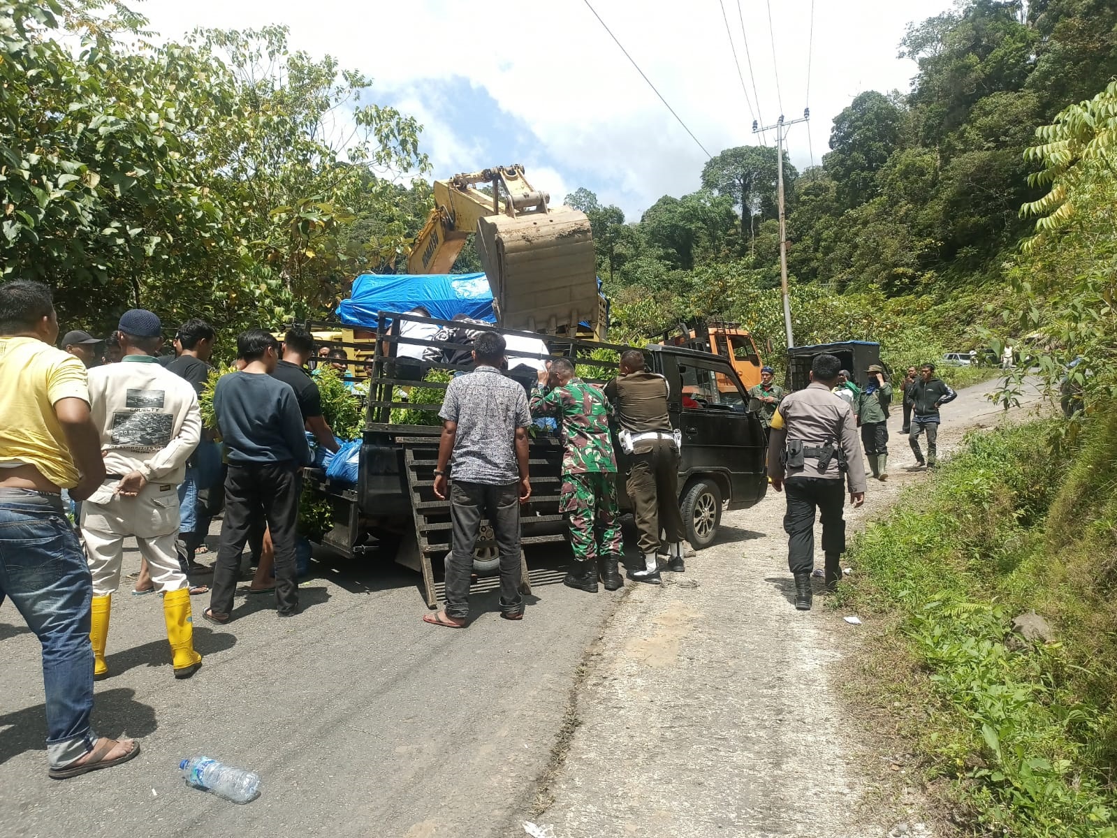 TRAGEDI: Petugas bersama warga saat mencoba mengevakuasi kendaraan dan alat berat yang tumbang di kawasan Rimbo Malampah, Pasaman, Rabu (3/12).