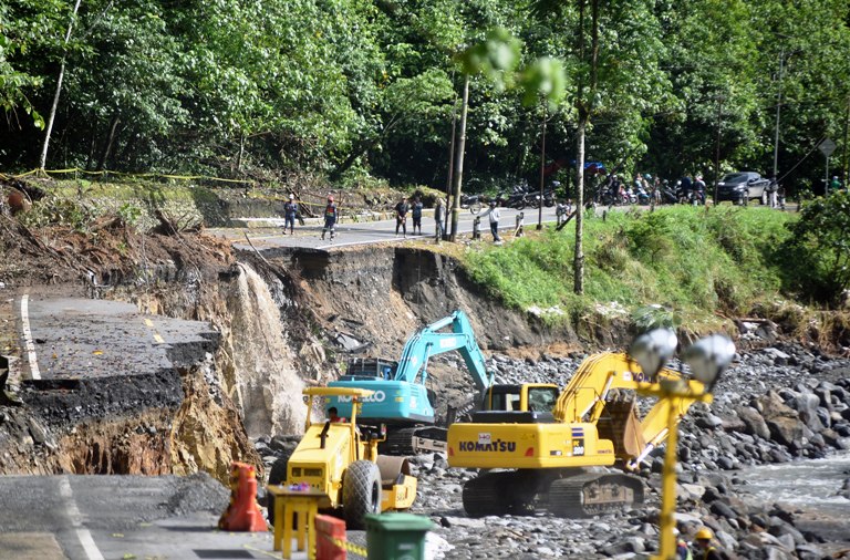 PENANGANAN JALAN PUTUS: Pekerja mengoperasikan alat berat dalam penanganan jalan putus akibat banjir bandang di kawasan Megamendung, Lembahanai, Kabupaten Tanahdatar, Kamis (4/12).